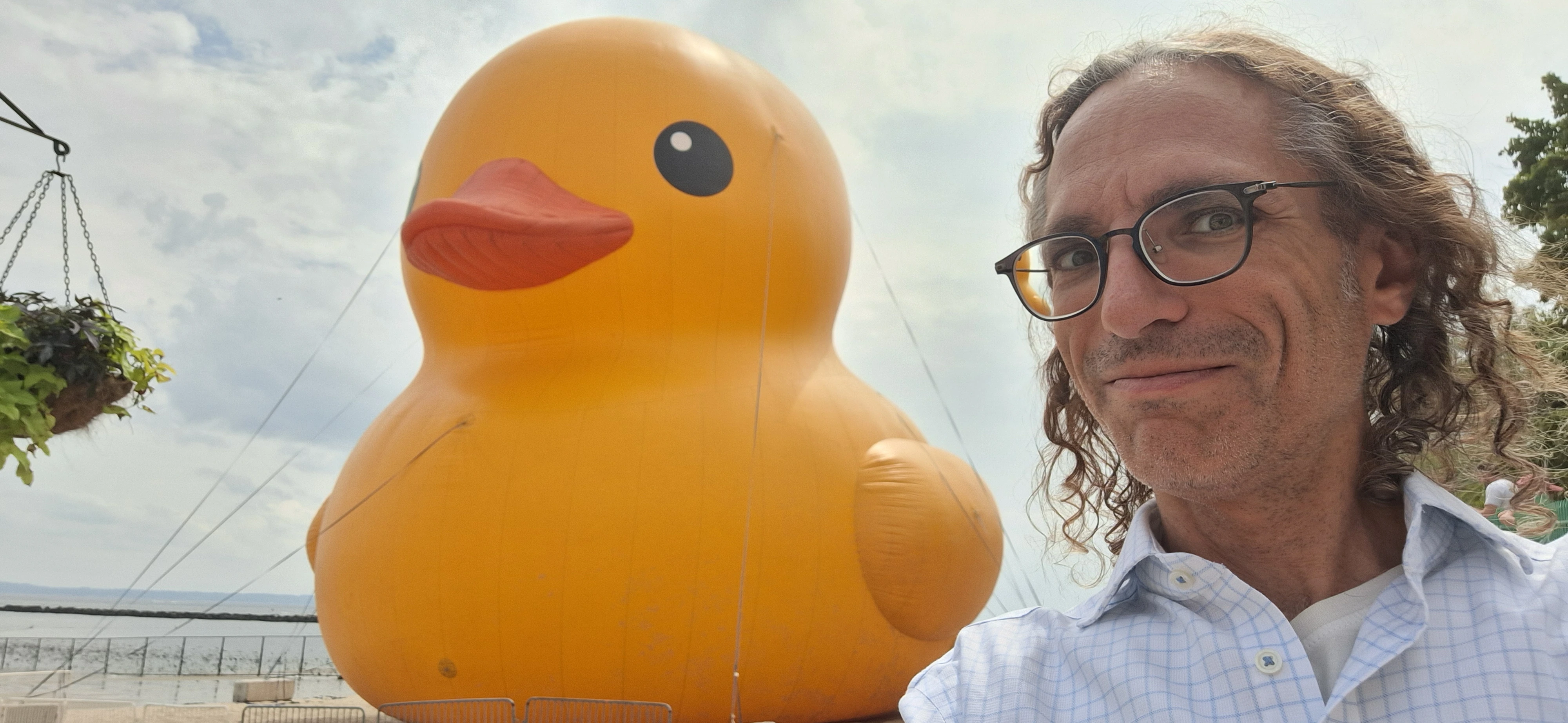Rick Massel smiling next to a massive floating yellow rubber duck.